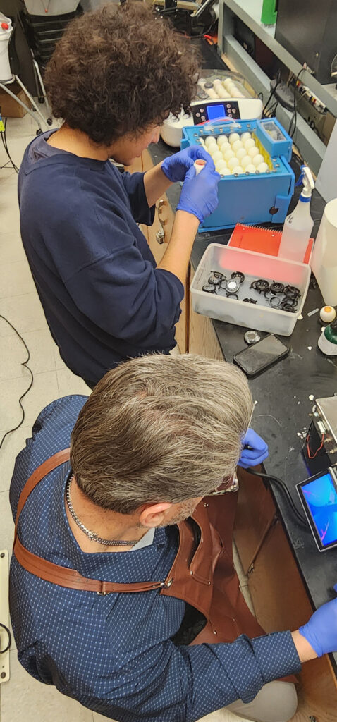 Bergen County Academies instructor Carlos Nodarse (right) works with student inventor Muhammed El-Sherbiny (left) to perform research inside eggs using an entire system designed by El-Sherbiny to transform chicken eggs into research models using lasers to cut into the shells while preserving the eggs' protective membranes.