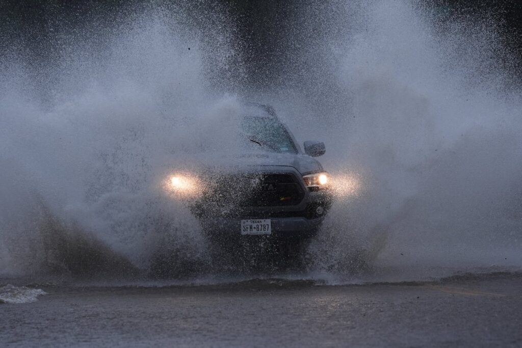 A vehicle navigates a flooded roadway as heavy rain move through the area, in San Antonio, Thursday, Oct. 1, 2026. (AP Photo/Eric Gay)