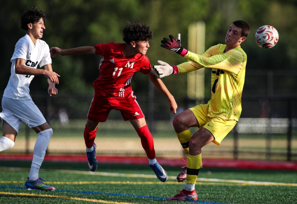 Jake Ramella (11) of Manalapan scores the game-winning goal in overtime on a header past Christian Brothers keeper Brady Lepore during the boys soccer match between Manalapan and Christian Brothers at Manalapan Athletic Fields in Manalapan, NJ on 9/16/26.